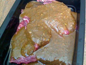 Flap steak marinating in chimichurri sauce